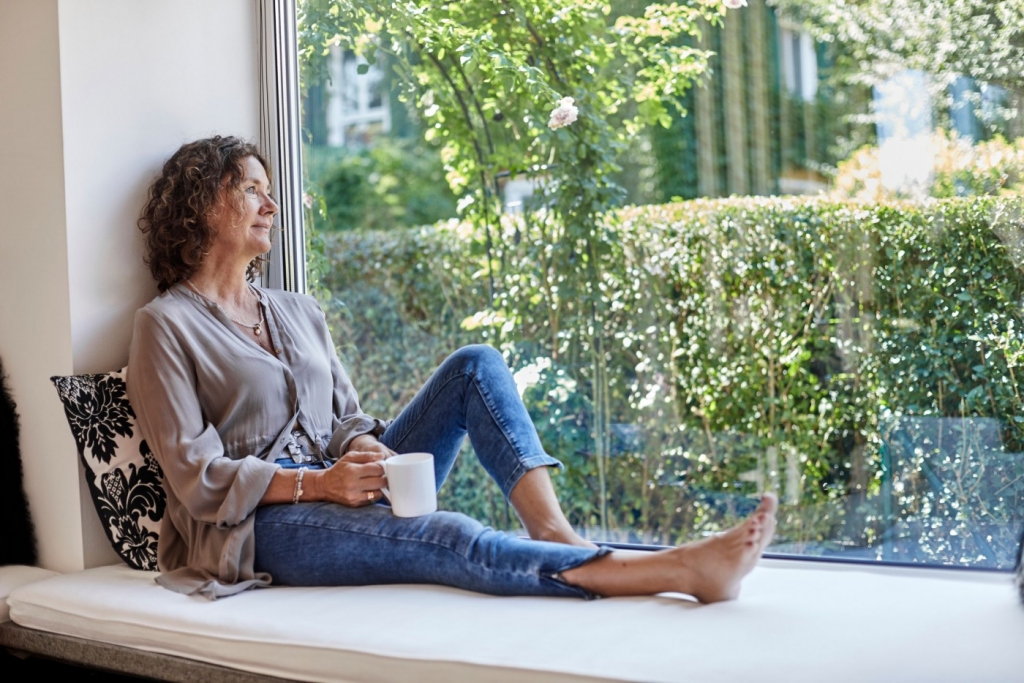Woman sitting beside a window